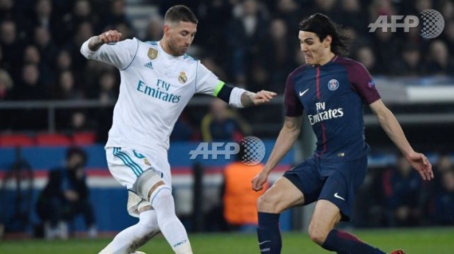 Pemain Real Madrid, Sergio Ramos berebut bola dengan penyerang PSG, Edinson Cavani dalam leg ke-2 Babak 16 Besar Liga Champion. (Christhope Simon / AFP)