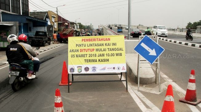 Pekerja mengerjakan penutupan pintu perlintasan rel kereta api (KA) sebidang di Jalan Cipinang Lontar, Jakarta, Rabu (7/3). 