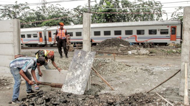 Pekerja mengerjakan penutupan pintu perlintasan rel kereta api (KA) sebidang di Jalan Cipinang Lontar, Jakarta, Rabu (7/3). 