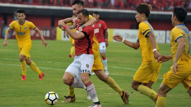 Pesepak bola Bali United Ilija Spasojevic (tengah) berebut bola dengan pesepak bola FLC Thanh Hoa, Vietnam Nguyen Van Bakel (ketiga kanan) dalam pertandingan Grup G Piala AFC 2018 di Stadion I Wayan Dipta, Gianyar, Bali, Rabu (7/3). 