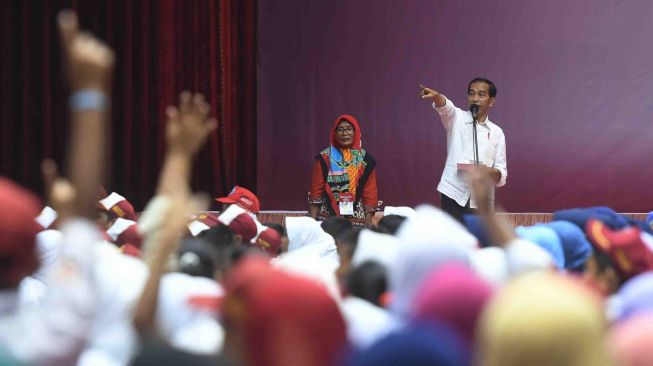 Presiden Joko Widodo (kanan) mengajukan pertanyaan kepada siswa saat penyerahan Kartu Indonesia Pintar dan Program Keluarga Harapan di Gor Tri Dharma, Gresik, Jawa Timur, Kamis (8/3). 