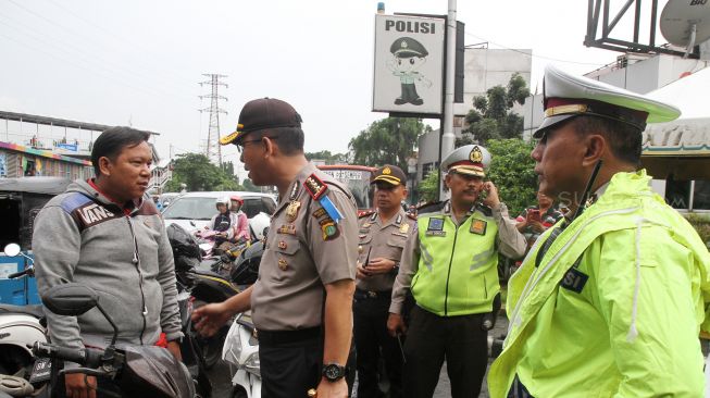 Satuan Lalu lintas Polres Jakarta Pusat membagikan helm kepada sejumlah pengendara motor yang tidak memakai helm di kawasan Pasar Senen, Jakarta, Kamis (8/3). 