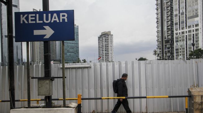 Pejalan kaki melintasi pedestrian di area perkantoran di kawasan Jalan Sudirman, Jakarta, Jumat (9/3). 