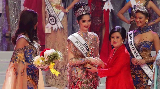 Menko PMK Puan Maharani (kedua kanan) menyerahkan piala kepada Puteri Indonesia 2018 Sonia Fergina Citra (kedua kiri) disaksikan oleh Puteri Indonesia 2017 Bunga Jelita Ibrani (kiri) dan Miss Universe 2017 Demi-Leigh Nel-Peters (kanan) dalam malam final Puteri Indonesia 2018 di JCC, Senayan, Jakarta, Sabtu (10/3).