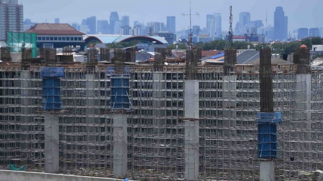 Pekerja melintas proyek pembangunan infrastruktur depo Light Rail Transit (LRT) di Kelapa Gading, Jakarta, Sabtu (10/3). 