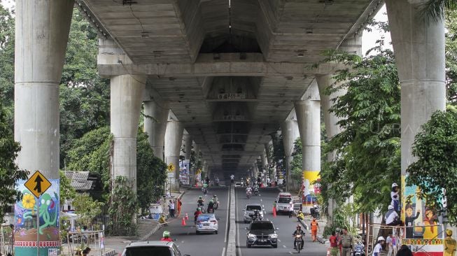 Sejumlah pelajar tingkat SMA se-Jakarta menghias 63 tiang penyangga jalan layang non tol di sepanjang Jalan  Antasari, Jakarta, Minggu (11/3/2018) [Suara.com/Kurniawan Mas'ud]