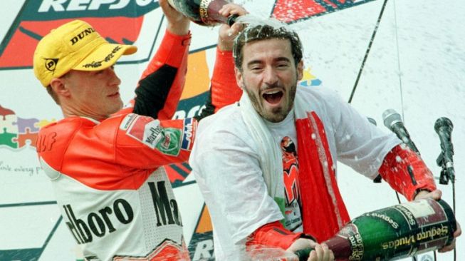 Ralf Waldmann merayakan keberhasilannya merayakan podium bersama rekan setimnya Max Biaggi pada balapan kelas 250 cc GP Australia di Sirkuit Phillip Island, 5 Oktober 1997. [AFP/Torsten Blackwood]