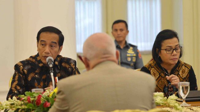 Presiden Joko Widodo (kiri) didampingi Menteri Keuangan Sri Mulyani menyampaikan paparan ketika menerima delegasi Asian Infrastructure Investment Bank (AIIB) di Istana Kepresidenan Bogor, Jawa Barat, Senin (12/3). 