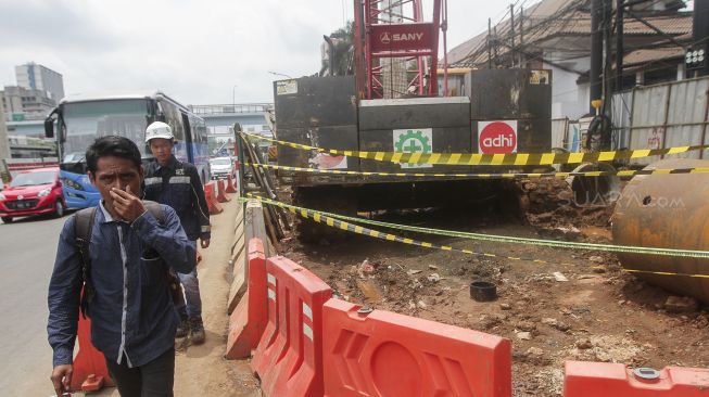 Sejumlah pekerja membersihkan sisa semburan lumpur gas PGN yang bocor di halaman kantor Badan Narkotika Nasional (BNN) di Cawang, Jakarta, Selasa (13/2). 