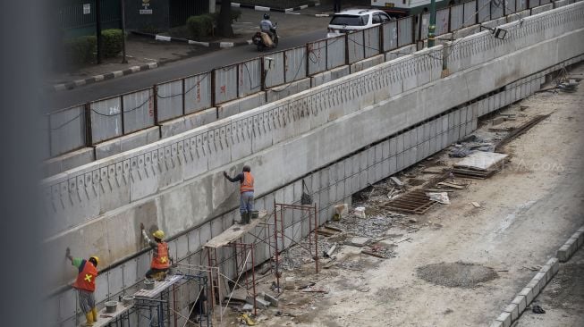 Pekerja menyelesaikan pembangunan underpass Mampang di Jakarta, Rabu (14/3). 