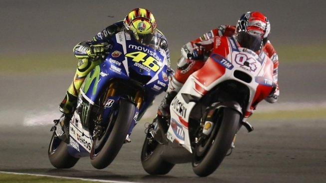  Pebalap Movistar Yamaha, Valentino Rossi, menguntit rider Ducati, Andrea Dovizioso, saat balapan seri perdana MotoGP 2015 di Sirkuit Losail, Qatar. [AFP/Karim Jaafar]