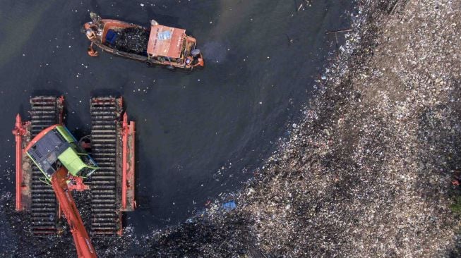 Alat berat dioperasikan untuk membersihkan sampah di kawasan Hutan Mangrove, Muara Angke, Jakarta, Selasa (20/3).