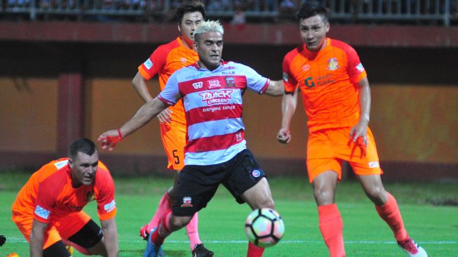 Pemain Madura United (MU) Cristian Gonzales (tengah) berusaha melewati pesepak bola Hougang United Singapura Adam Metter (kiri) dan Faiz S. dalam laga uji coba internasional di Stadion Gelora Ratu Pamelingan (SGRP) Pamekasan, Jawa Timur, Minggu (4/3). [ANTARA]