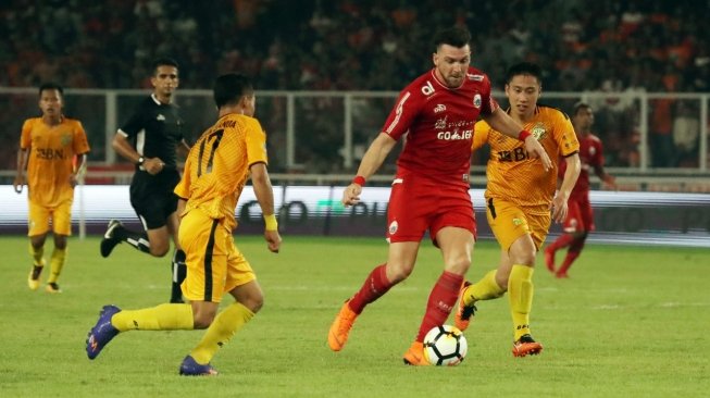 Striker Persija Jakarta, Marko Simic berduel dengan pemain Bhayangkara FC pada Jumat (23/3). (Foto: Media Persija).