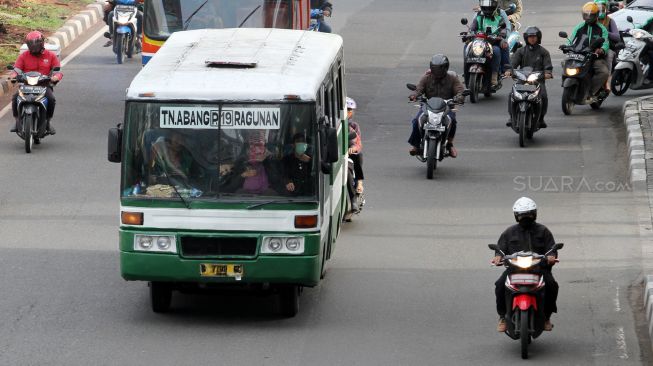 Bus Kopaja dan Metromini melintas di Jalan Jenderal Sudirman, Jakarta, Jumat (23/3).