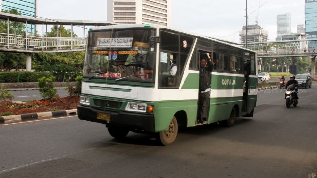 Bus Kopaja dan Metromini melintas di Jalan Jenderal Sudirman, Jakarta, Jumat (23/3). 