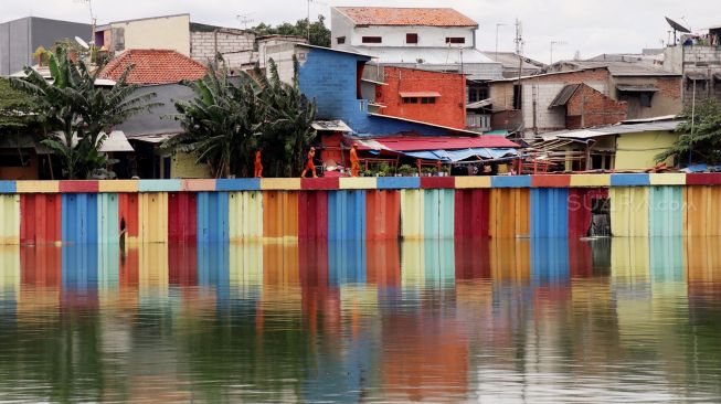 Petugas PPSU melakukan pengecatan ‘Kampung Warna Warni’ di kawasan Danau Sunter, Jakarta, Jumat (23/3). 