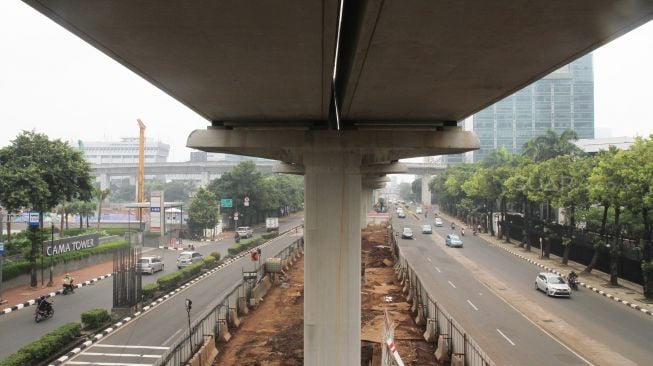 Pekerja menyelesaikan pembangunan proyek kereta ringan atau light rail transit Jakarta-Bogor-Depok-Bekasi (LRT Jabodebek) di kawasan Kuningan, Jakarta, Jumat (24/3/2018). [Suara.com/Oke Atmaja]