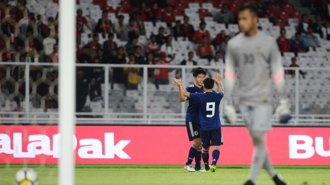 Pesepak bola Jepang U-19 Ando Mizuki (kiri) bersama rekannya Hori Kenta (tengah) merayakan gol yang ia cetak ke gawang Timnas U-19 yang dikawal oleh penjaga gawang M Aqil Savic (kanan) dalam laga persahabatan di Stadion Utama Gelora Bung Karno, Jakarta, Minggu (25/3). Indonesia kalah dari Jepang dengan skor akhir 1-4. ANTARA