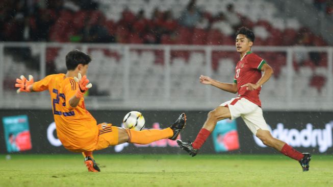 Pesepak bola Timnas U-19 Aji Kusuma (kanan) melakukan tembakan yang coba diblok penjaga gawang Jepang U-19 Tani Kosei dalam laga persahabatan di Stadion Utama Gelora Bung Karno, Jakarta, Minggu (25/3). Indonesia kalah dari Jepang dengan skor akhir 1-4. ANTARA