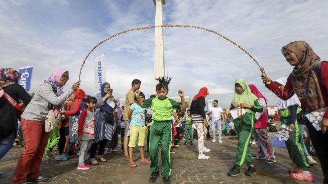 Permainan tradisional yang populer di masyarakat Indonesia terancam punah, tergeser oleh permainan digital. Sejumlah anak dan orangtua ini kembali menunjukkan permainan itu di Silang Monas. (Suara.com/Kurniawan Mas'ud)