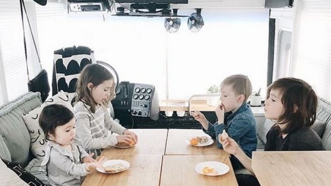 Ruang makan dalam bus sekolah yang telah disulap menjadi rumah bergerak (mobile home). (@themayesteam/Instagram)