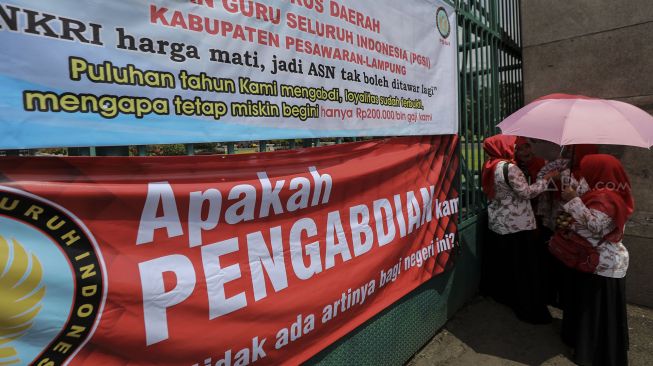 Ratusan Guru swasta yang tergabung dalam Persatuan Guru Seluruh Indonesia (PGSI) menggelar unjuk rasa di depan Kompleks Parlemen, Senayan, Jakarta, Selasa (27/3).