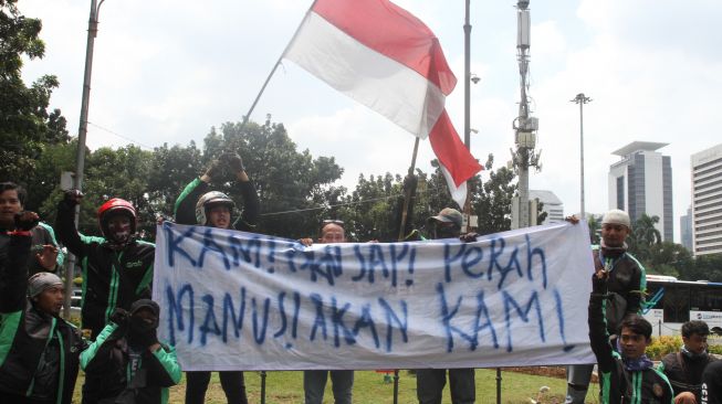 Ribuan driver ojek online (Ojol) berunjuk rasa di Jalan Medan Merdeka, Jakarta, Selasa (27/3).