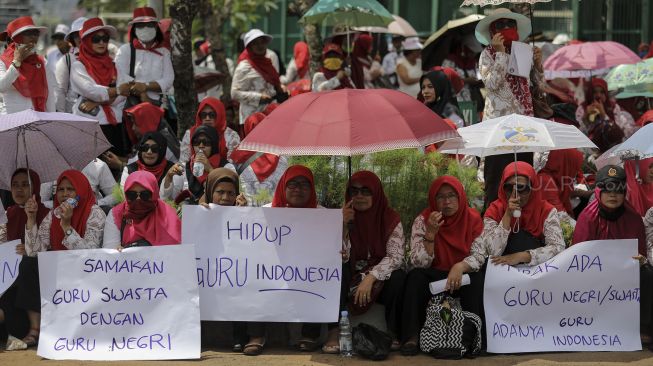 Ratusan Guru swasta yang tergabung dalam Persatuan Guru Seluruh Indonesia (PGSI) menggelar unjuk rasa di depan Kompleks Parlemen, Senayan, Jakarta, Selasa (27/3).