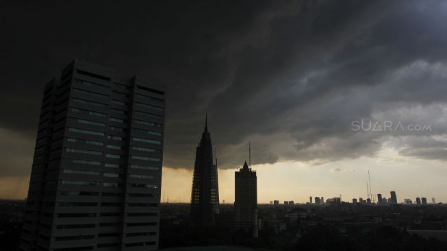 Awan mendung di atas gedung pencakar langit sesaat sebelum hujan deras mengguyur di wilayah Jakarta, Kamis (29/3).