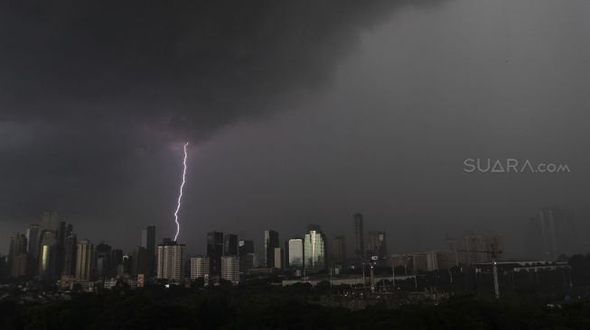 Awan mendung di atas gedung pencakar langit sesaat sebelum hujan deras mengguyur di wilayah Jakarta, Kamis (29/3).