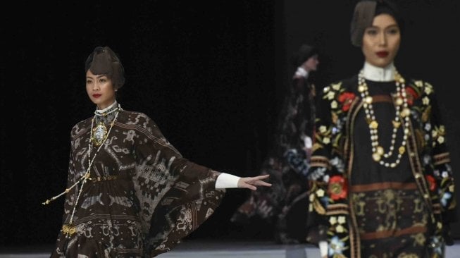 Model mengenakan busana rancangan Itang Yunas saat peragaan busana pada Indonesia Fashion Week 2018 di Jakarta Convention Center, Jakarta, Jumat (30/3). 