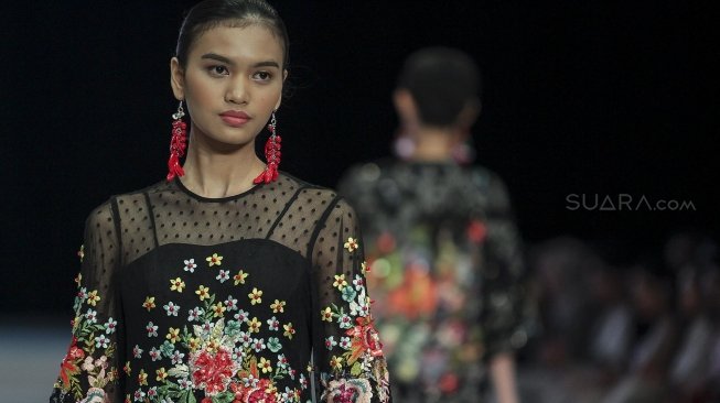 Model mengenakan busana rancangan dari delapan desainer dibawah label kosmetik Wardah pada Indonesia Fashion Week 2018 di Jakarta Convention Center, Jakarta, Sabtu (31/3) malam [Suara.com/Kurniawan Mas'ud]