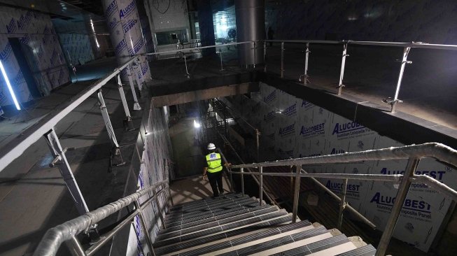 Pekerja menuruni tangga di Stasiun MRT Bundaraan HI, Jakarta, Kamis (5/4). 