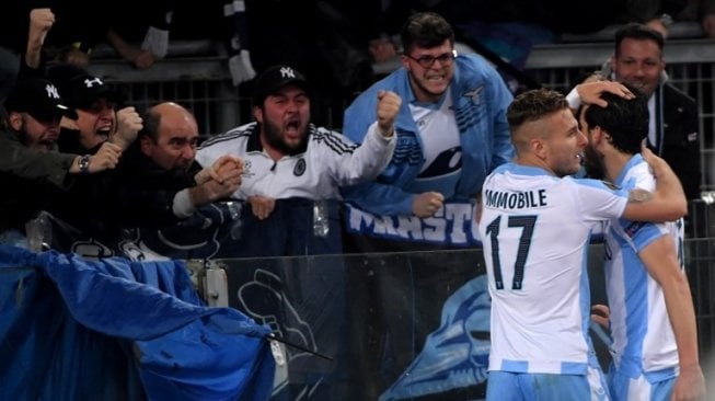 Gelandang Lazio Marco Parolo (kanan) merayakan golnya dengan fans dan juga Ciro Immobile. TIZIANA FABI / AFP