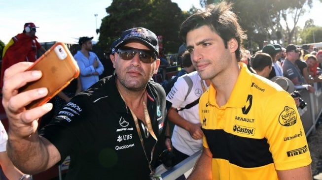 Pebalap F1 dari tim Renault, Carlos Sainz Jr (kanan) berfoto bersama penggemar jelang balapan GP Australia, Minggu (25/3/2018). [AFP/William West]