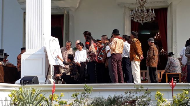 Temui Budayawan di Istana, Jokowi Jongkok Tulis Sesuatu di Kanvas