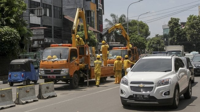 Petugas Unit Peralatan dan Perbekalan (Alkal) Dinas Bina Marga DKI Jakarta memasang beton pembatas jalan di kawasan Jalan Proklamasi Jakarta, Selasa (10/4).