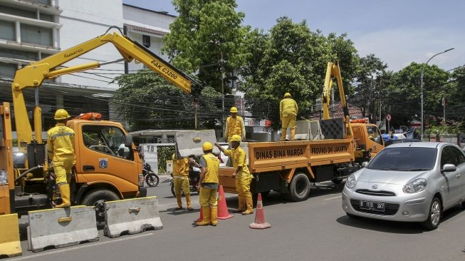 Petugas Unit Peralatan dan Perbekalan (Alkal) Dinas Bina Marga DKI Jakarta memasang beton pembatas jalan di kawasan Jalan Proklamasi Jakarta, Selasa (10/4).