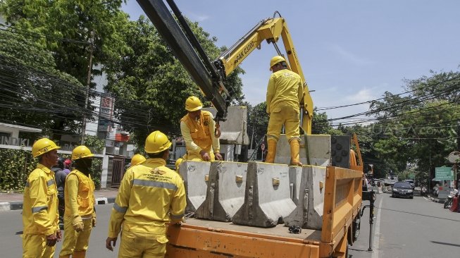 Petugas Unit Peralatan dan Perbekalan (Alkal) Dinas Bina Marga DKI Jakarta memasang beton pembatas jalan di kawasan Jalan Proklamasi Jakarta, Selasa (10/4).