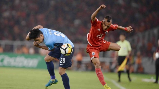 Pesepak bola Persija Jakarta Riko Simanjuntak (kanan) berebut bola dengan pesepak bola Johor Darul Ta'zim (JDT) Muhammad Syafiq dalam laga lanjutan Piala AFC di Stadion Utama Gelora Bung Karno, Senayan, Jakarta, Selasa (10/4). 