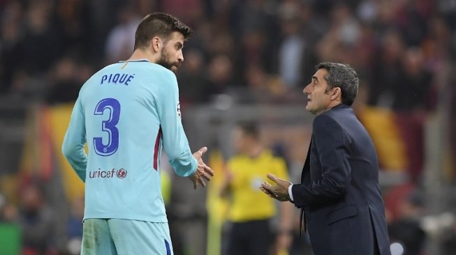 Pelatih Barcelona Ernesto Valverde berbicara dengan Gerard Pique saat menghadapi AS Roma di Stadio Olimpico [AFP]