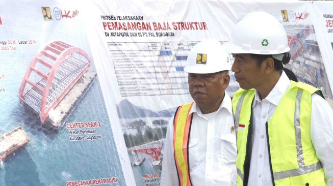 Presiden Joko Widodo (kanan) didampingi Menteri Pekerjaan Umum dan Perumahan Rakyat (PUPR) Basuki Hadimuljono (kiri) meninjau proyek pembangunan Jembatan Holtekamp di Jayapura, Papua, Kamis (12/4).