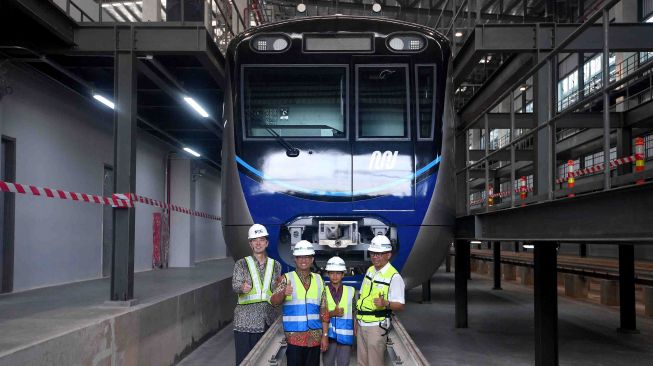 Gubernur DKI Jakarta Anies Baswedan (kedua kiri) bersama anaknya Kaisar Hakam (kedua kanan), didampingi Direktur Utama PT MRT Jakarta William Sabandar (kanan) dan Wakil Duta Besar Jepang untuk Indonesia Kozo Honsei (kiri) berfoto bersama di depan kepala kereta MRT di Depo MRT Lebak Bulus, Jakarta, Kamis (12/4).