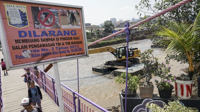 Pengerukan lumpur yang mengendap di bawah sungai Kanal Banjir Barat di kawasan Kota Bambu, Tomang, Jakarta, Kamis (12/4). 