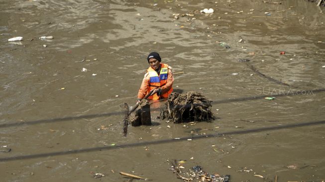 Pengerukan lumpur yang mengendap di bawah sungai Kanal Banjir Barat di kawasan Kota Bambu, Tomang, Jakarta, Kamis (12/4). 