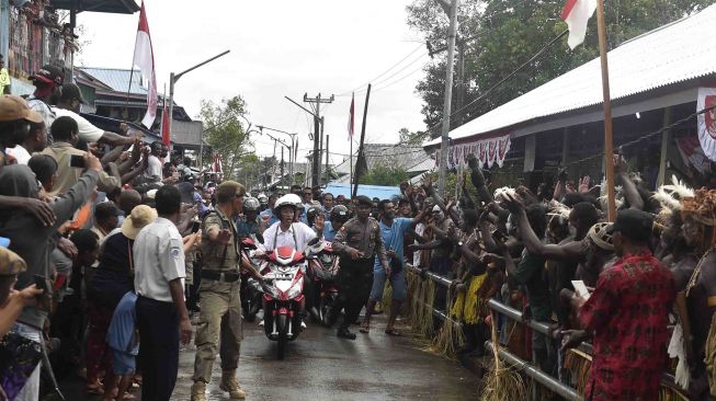 Presiden Joko Widodo berboncengan dengan Ibu Negara Iriana Joko Widodo menyapa warga saat kunjungan kerja di Distrik Agats, Kabupaten Asmat, Papua, Kamis (12/4). 