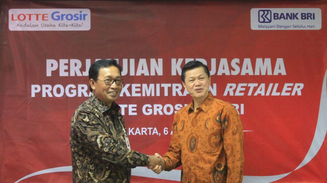 Direktur Hubungan Kelembagaan Bank BRI Sis Apik Wijayanto memberikan plakat penghargaan kepada Presiden Director Lotte Shopping Indonesia  Joseph V. Buntaran usai mendatangani perjanjian kerjasama Layanan dan  Jasa Perbankan, di Head Office Lotte Jakarta, Kamis (12/4).