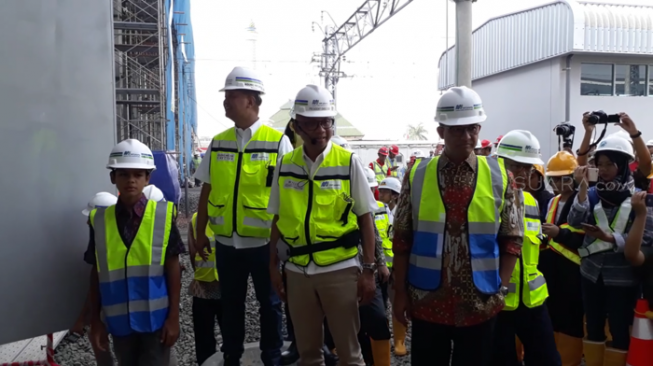 Gubernur Jakarta Anies Baswedan dan putranya, Kaisar Hakam Baswedan (12), meninjau pengerjaan proyek rangkaian kereta mass rapid transit (MRT) di Depo MRT, Lebak Bulus, Jakarta, Kamis (12/4/2018). [Suara.com/Ummi Hadyah Saleh]