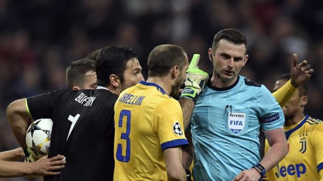 Kapten Juventus Gianluigi Buffon menunjuk-nunjuk wasit Michael Oliver ketika memprotes keputusan wasit asal Inggris itu memberikan penalti kepada Real Madrid [AFP]